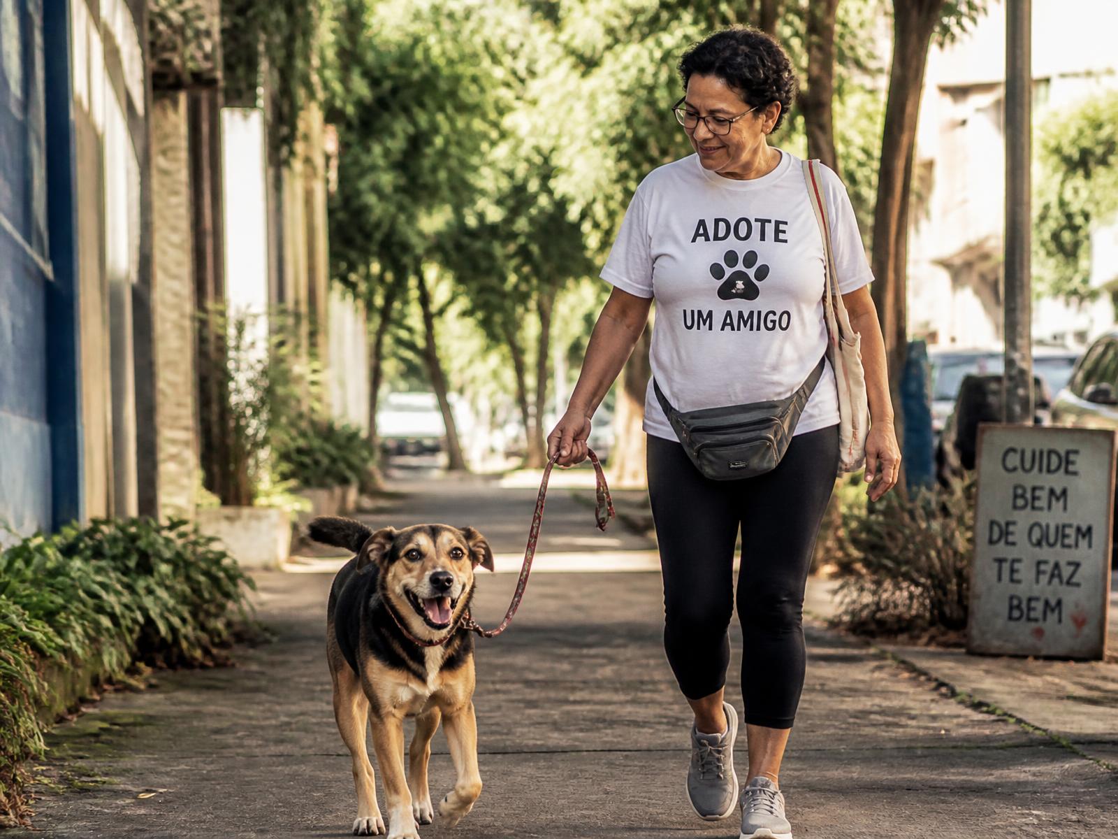 Tutora caminhando com seu cão em uma rua arborizada